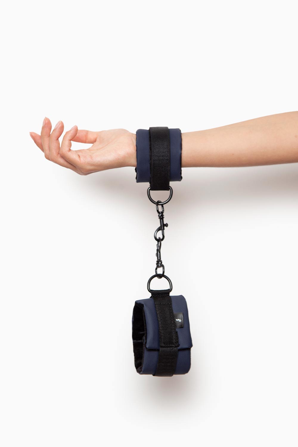 Mano sujetando esposas de velcro del Kit Atrevida, suaves y seguras para primeros juegos BDSM