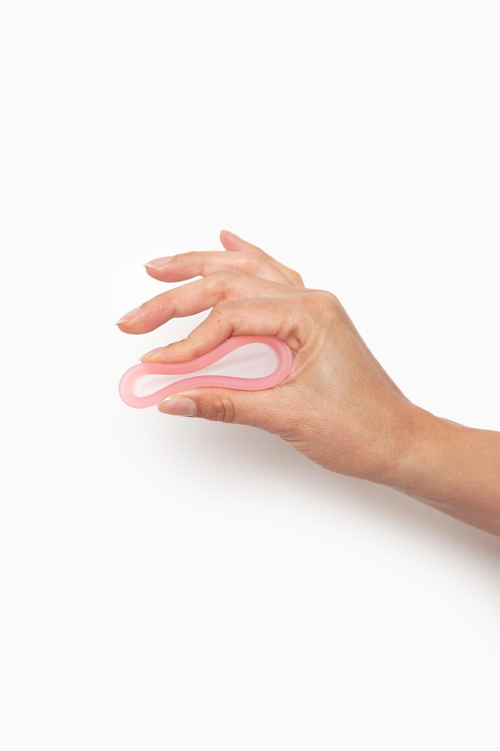 Demostración del uso del disco menstrual presionándolo con una mano para facilitar su inserción vaginal